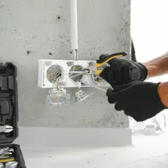 Elektryk montuje gniazdka. Sprawdź, jaka jest montaż gniazdka cena i jak szybko można to zrobić.