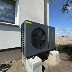 Nowoczesna pompa ciepła Geo Power zamontowana na betonowych bloczkach. Rozważasz inwestycję? Sprawdź, jaki pompa ciepła koszt.
