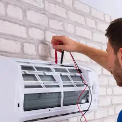Technik sprawdza klimatyzację. Dowiedz się, ile kosztuje serwis klimatyzacji, aby zapewnić jej sprawność.