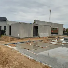 Budowa domu z wielkiej płyty w toku. Betonowe ściany i strop czekają na dalsze prace.