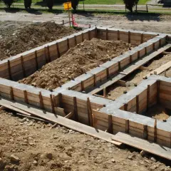 Betonowy fundament w drewnianym szalunku, gotowy do dalszych prac budowlanych.