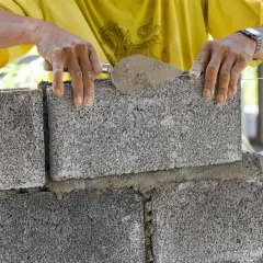 Budowniczy układa bloczki betonowe fundamentowe, tworząc solidną podstawę.