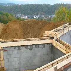 Fundamenty domu w budowie, zbrojenie i szalunki czekają na beton. Ważne pozwolenie na budowę to klucz do legalnego stawiania wymarzonego domu.
