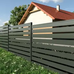 Nowoczesne ogrodzenie panelowe w ciemnoszarym kolorze, z drewnianymi wstawkami, otacza dom z czerwonym dachem. Idealne rozwiązanie, by poznać koszt ogrodzenia panelowego.