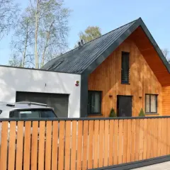 Nowoczesna dobudówka do starego domu, z drewnianą elewacją i garażem. Projekty uwzględniające harmonię z otoczeniem.