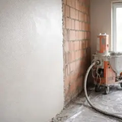 Miksokret w akcji, tynk na ścianie w trakcie prac.