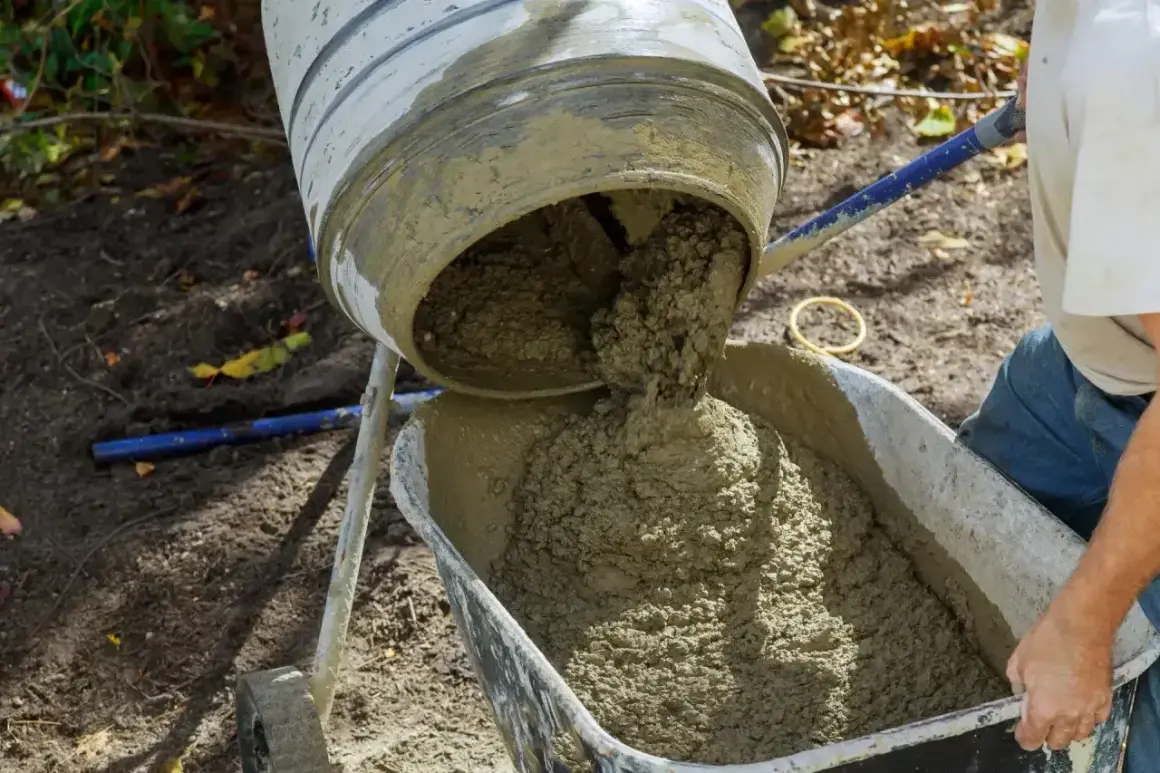 Beton B20 wylewany z betoniarki do taczki. Właściwe proporcje składników zapewniają trwałość konstrukcji.