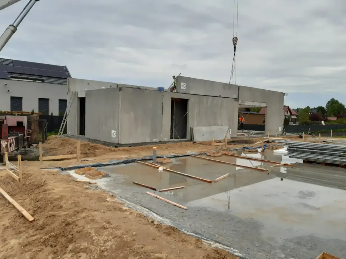 Budowa domu z wielkiej płyty w toku. Betonowe ściany i strop czekają na dalsze prace.