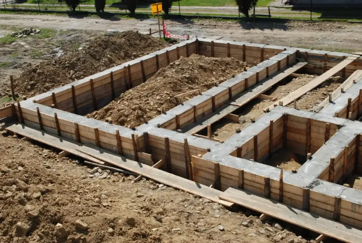 Betonowy fundament w drewnianym szalunku, gotowy do dalszych prac budowlanych.