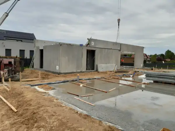 Budowa domu z wielkiej płyty w toku. Betonowe ściany i strop czekają na dalsze prace.