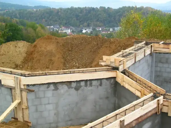 Fundamenty domu w budowie, zbrojenie i szalunki czekają na beton. Ważne pozwolenie na budowę to klucz do legalnego stawiania wymarzonego domu.